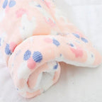 Close-up of a soft fabric with pink and blue polka dots on a white background
