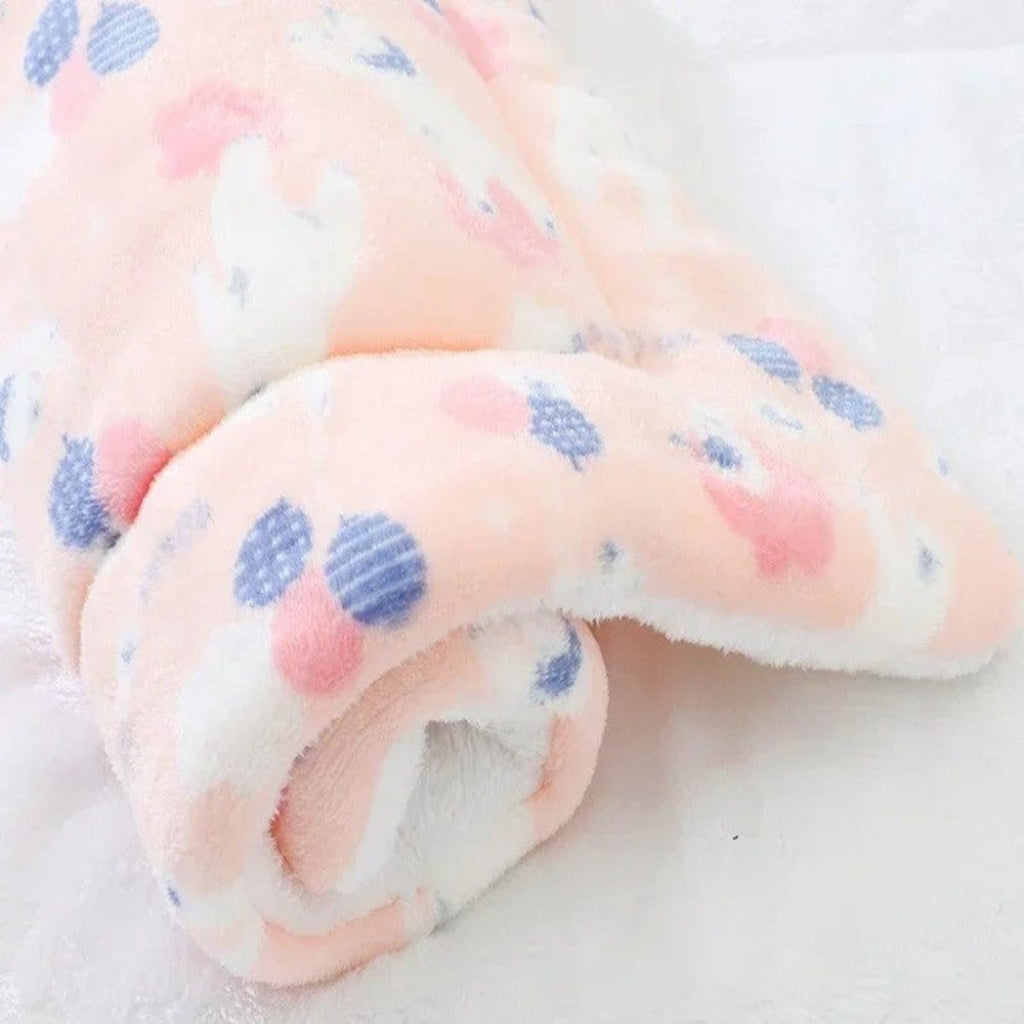 Close-up of a soft fabric with pink and blue polka dots on a white background