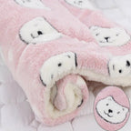 Pink fuzzy socks with white bear faces on a light pink background