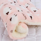 Pink plush blanket with brown heart patterns on a soft surface