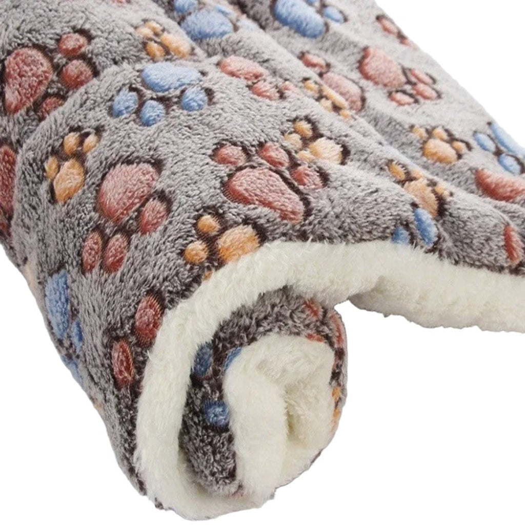 Roll of fleece fabric with paw print pattern on a white background