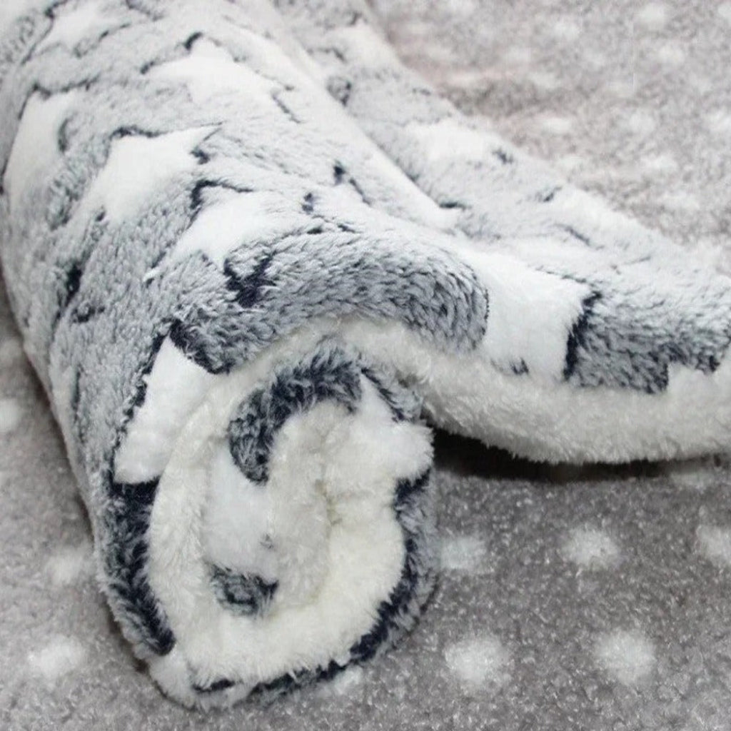 Roll of white fabric with black patterns on a textured surface