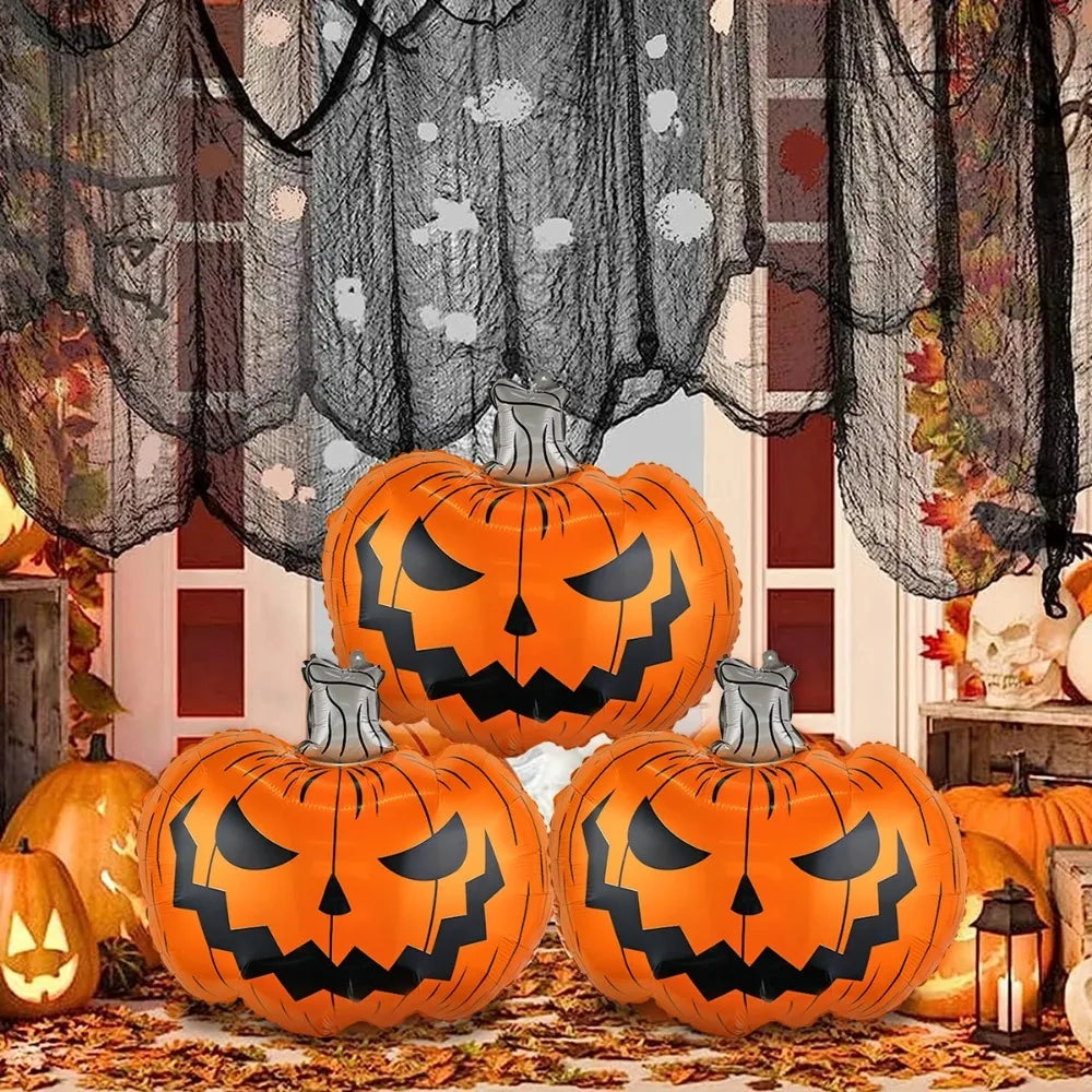 Three large inflatable jack-o'-lantern pumpkins with carved faces are displayed in a Halloween-themed setting with black netting, autumn leaves, lanterns, and smaller pumpkins.