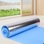 Roll of blue and silver insulation material on a floor with a window view of greenery outside.