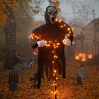 Ghost face scarecrow in front yard at night with Halloween lighting