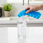 Hands flexing silicone tray to pop out honeycomb ice cubes