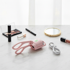 Pink heated eyelash curler on marble vanity flat lay